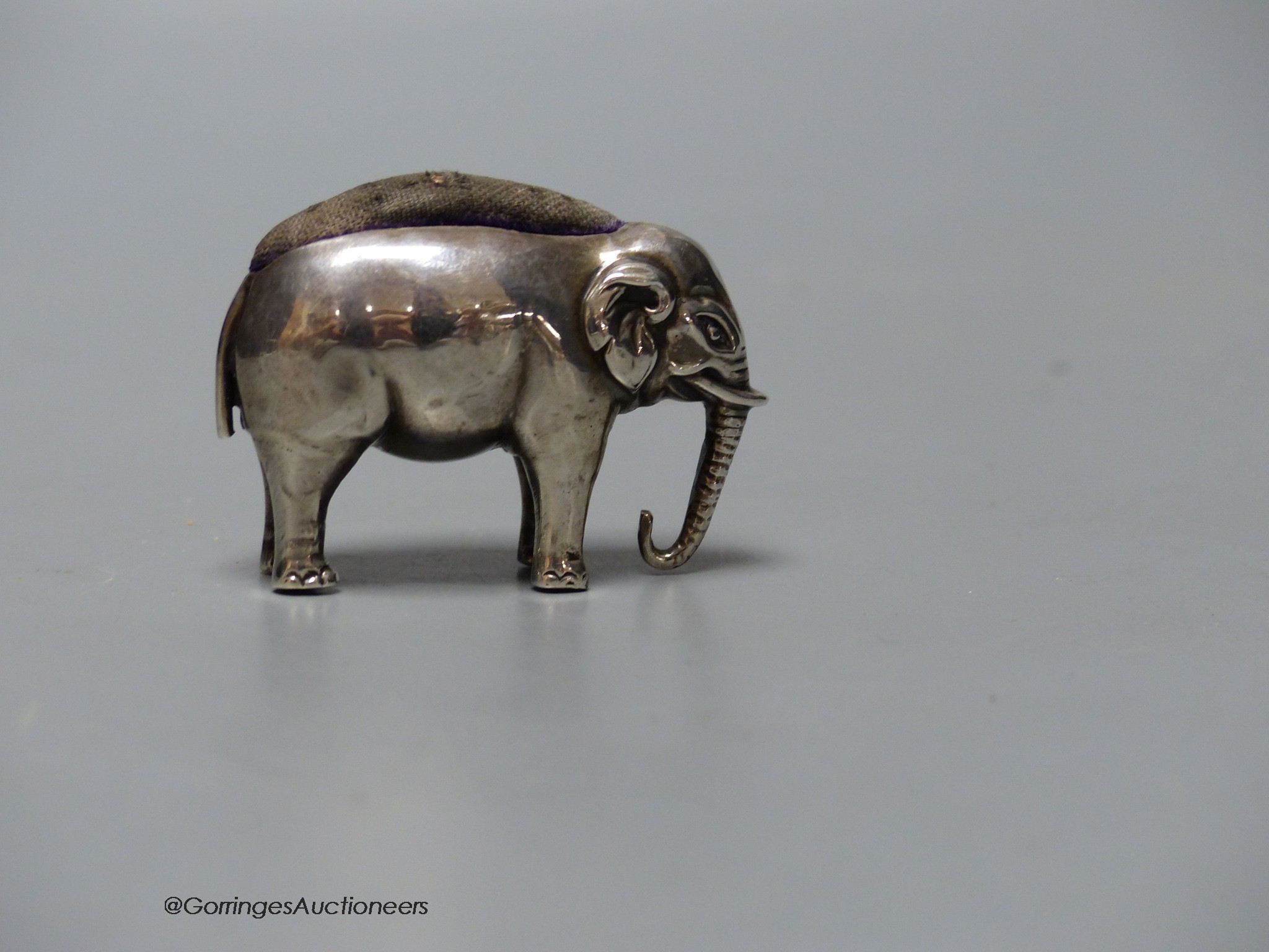 An Edwardian silver elephant pin cushion, Adie & Lovekin, Birmingham, 1906, length 48mm.